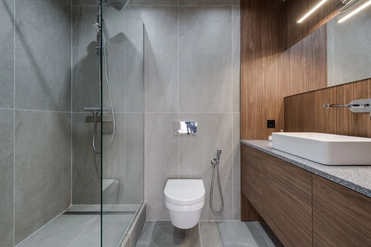 Salle de bains moderne avec douche vitrée de plain-pied, WC suspendu et meuble vasque en bois