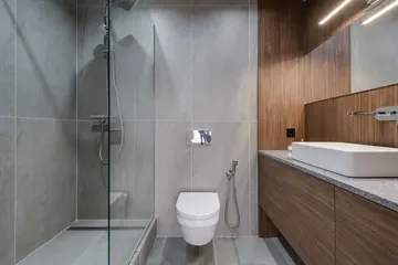 Salle de bains moderne avec douche vitrée de plain-pied, WC suspendu et meuble vasque en bois